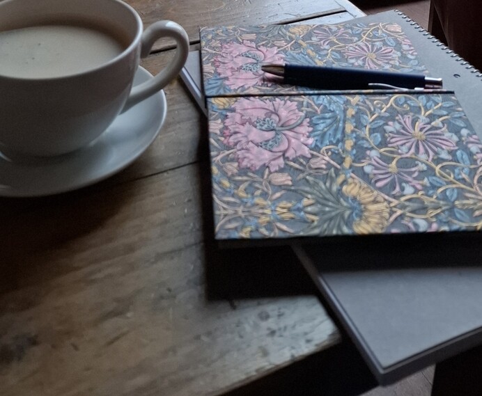 Tasse Kaffee und Notizbuch auf dem Tisch – Symbol für Mentaltraining und persönliches Wachstum