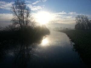 Morgendlicher Fluss im Nebel mit Sonnenlicht – Symbol für innere Ruhe, Klarheit und den Glauben an sich selbst auf dem Herzensweg