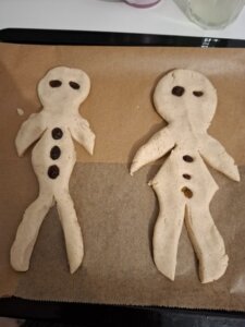 „Zwei misslungene Weihnachts-Weckmänner auf einem Backblech – Symbol für unperfekte, stressfreie Feiertage trotz Fibromyalgie“