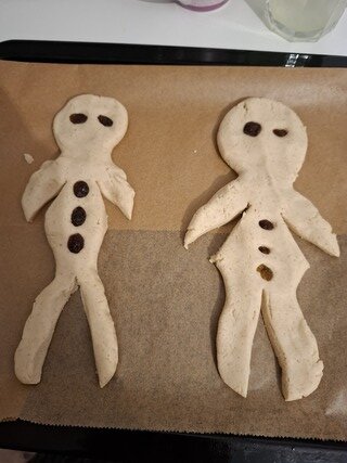 „Zwei misslungene Weihnachts-Weckmänner auf einem Backblech – Symbol für unperfekte, stressfreie Feiertage trotz Fibromyalgie“